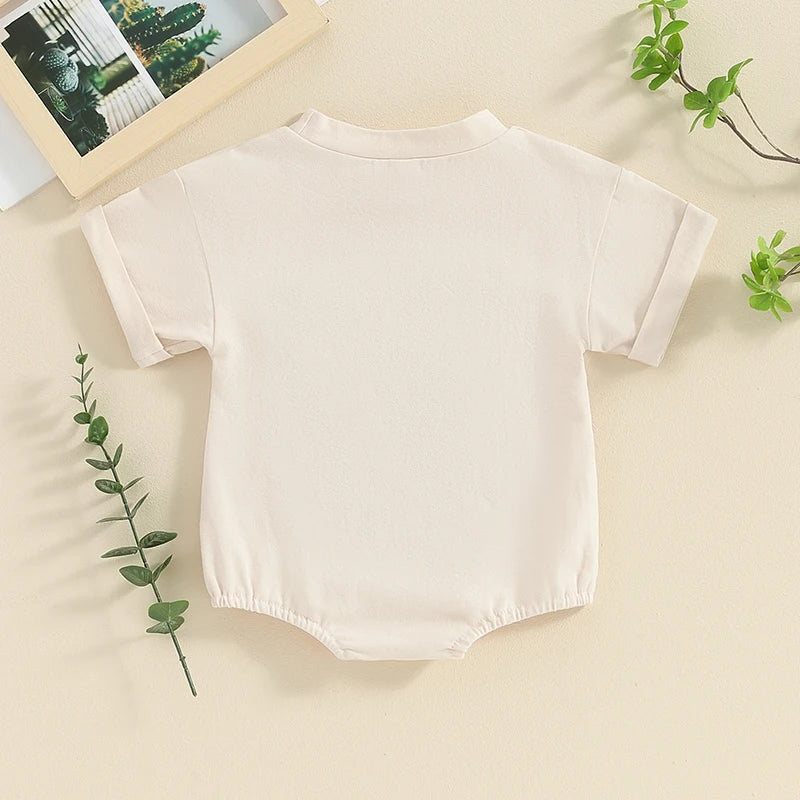 Back of "Moody" Short Sleeved Cow Onesie in Beige, short sleeved onesie for baby boy or baby girl, baby boutique, Jelly Bean Baby Co., on a decorated background