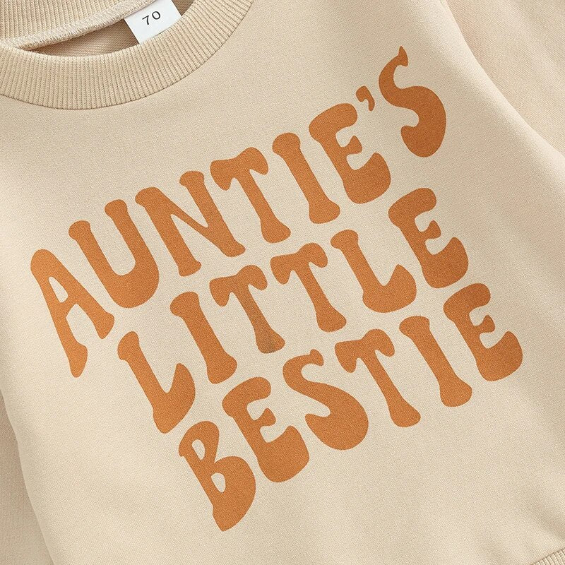 Closeup of font on front of sweatshirt for Two piece set that includes a khaki long sleeved sweatshirt that reads, "Auntie's Little Bestie' in brown font on the front with matching brown pants with pockets, for baby and toddler girl, baby boutique, Jelly Bean Baby Co.